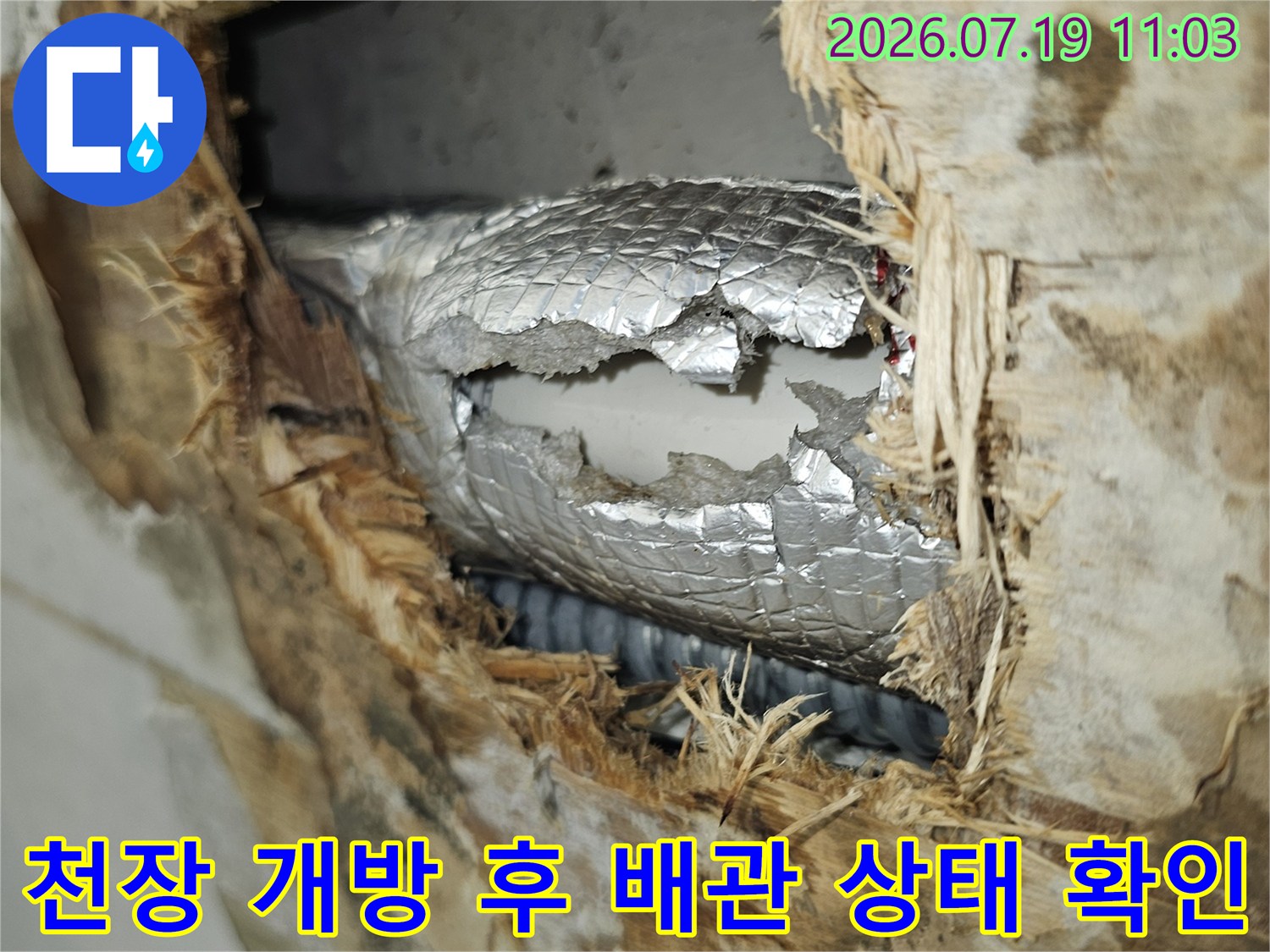물에 젖어 변색된 천장 마감재와 내부의 은색 배관 보온재 노출 사진