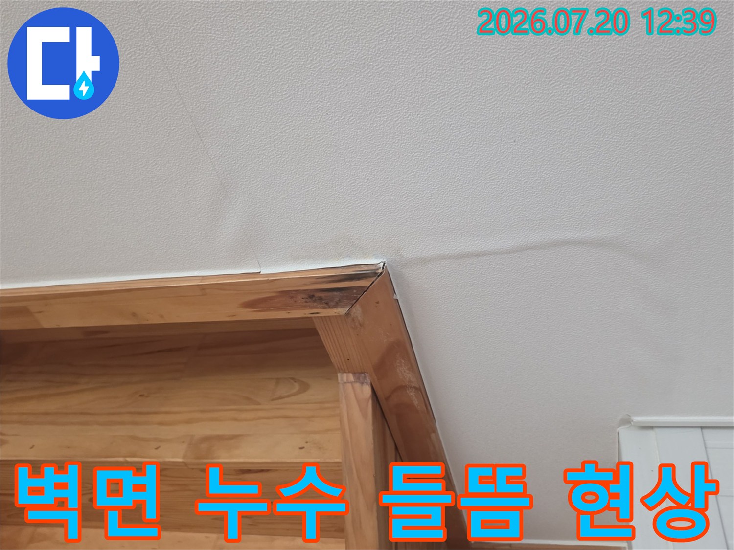 나무 선반 위쪽 벽지가 습기로 인해 팽창하여 표면이 고르지 못한 모습