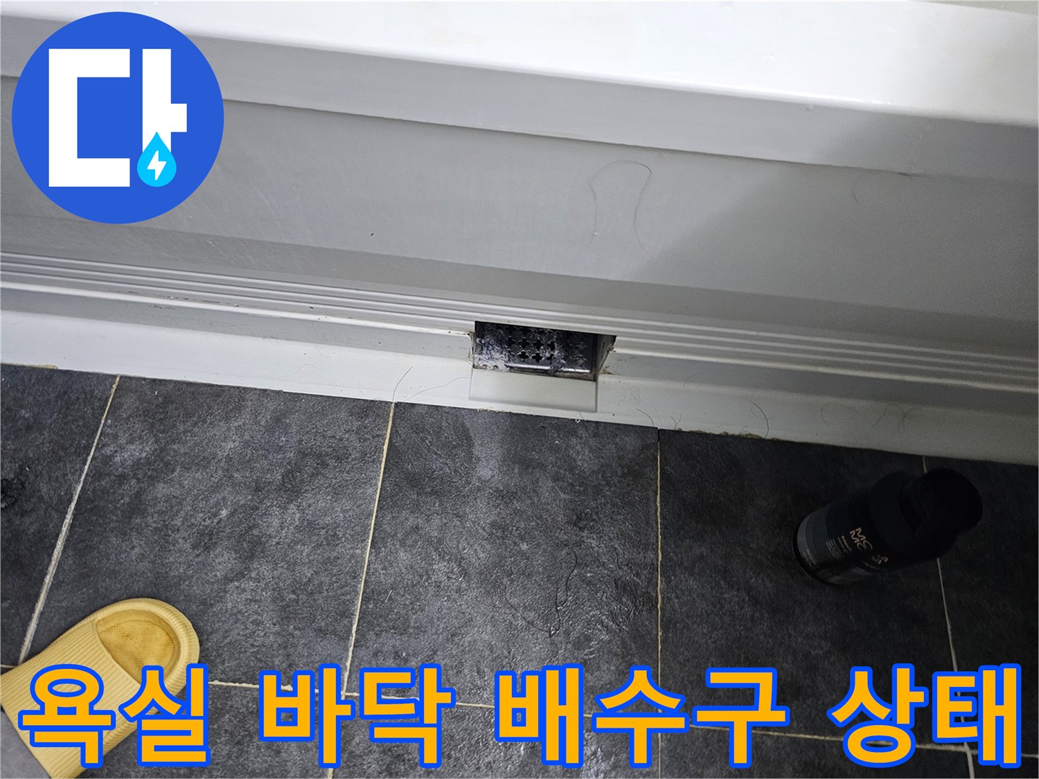 어두운 색상의 타일과 흰색 배수 장치 부근