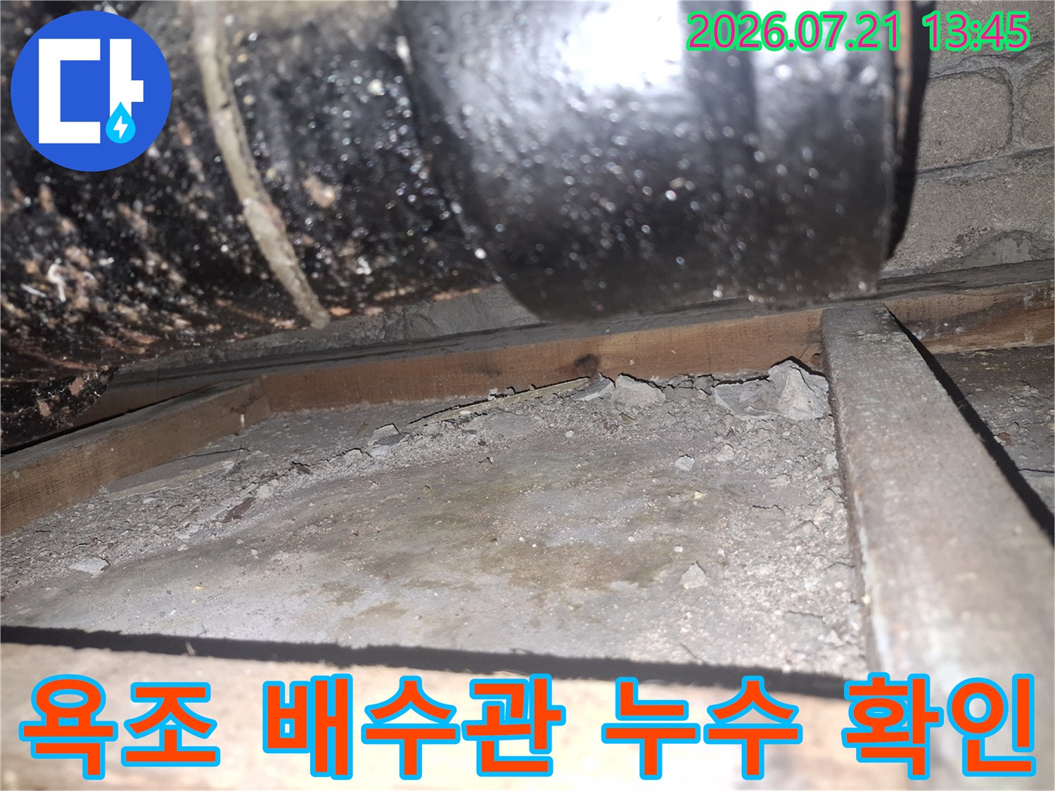 배수관 하단부에 고인 물과 노출된 배관 구조물
