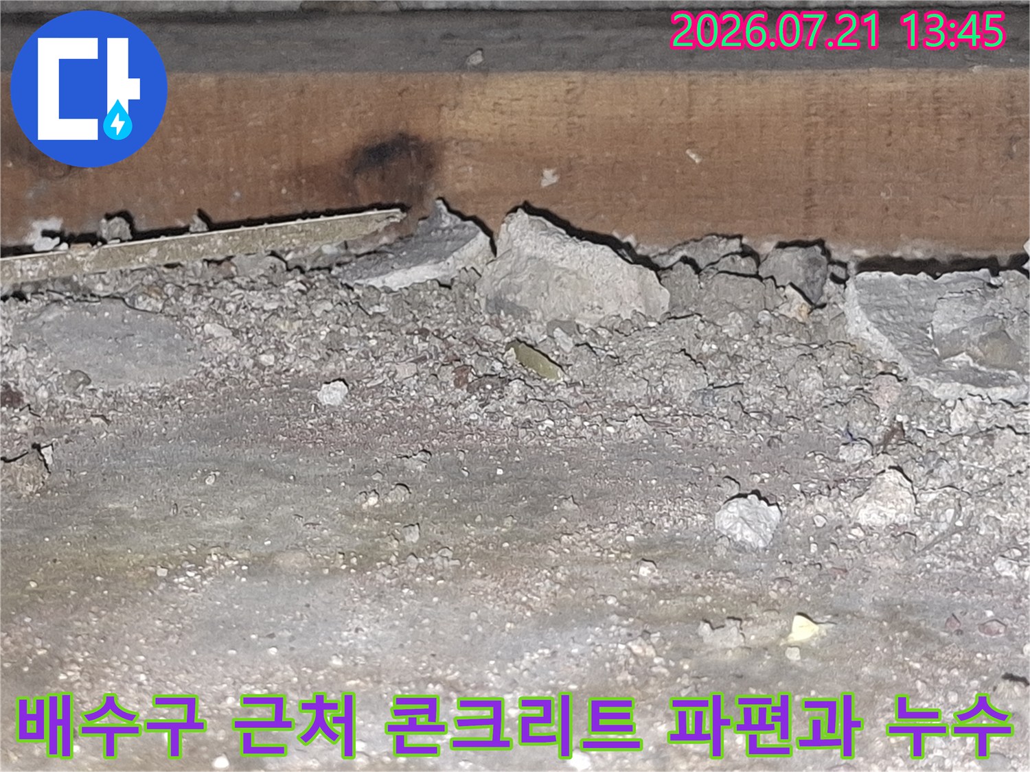 배출관 주변의 훼손된 콘크리트와 노출 배관의 상태를 보여주는 사진