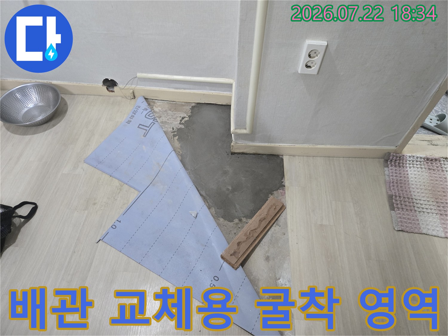 파헤친 바닥과 노출된 배관 및 작업 도면을 통해 수리 계획을 세우는 모습