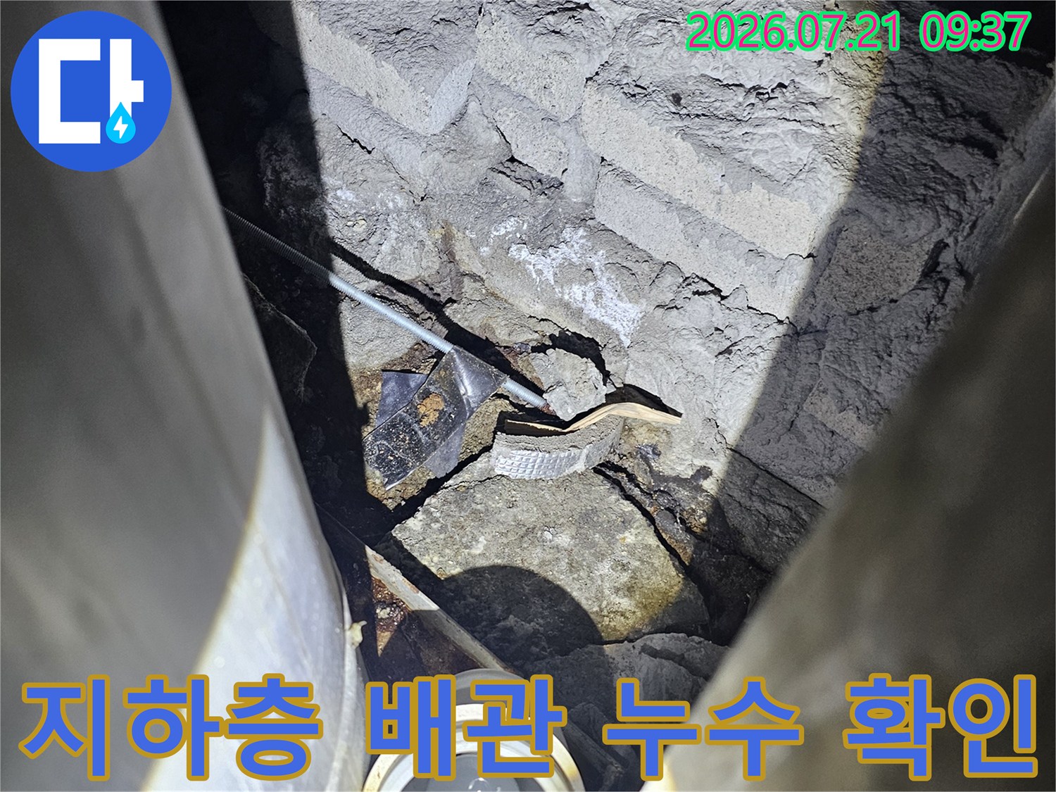 노출된 배관과 콘크리트 슬래브 사이의 균열을 점검하는 모습