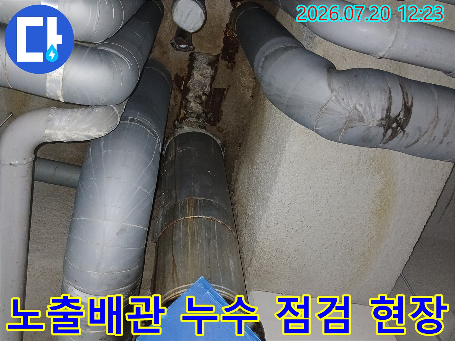 지하 주차장 천장에 노출된 배관과 연결 부위의 누수 흔적을 점검하는 모습