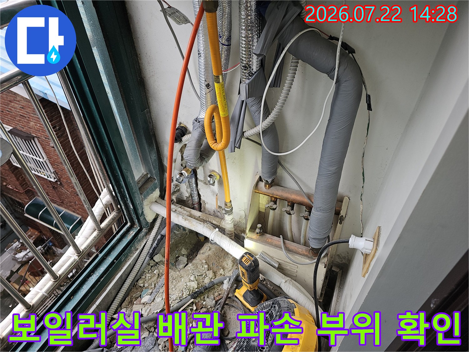 굴착된 벽면에서 발견된 노란색 직수 배관과 수리용 장비가 배치된 현장 모습