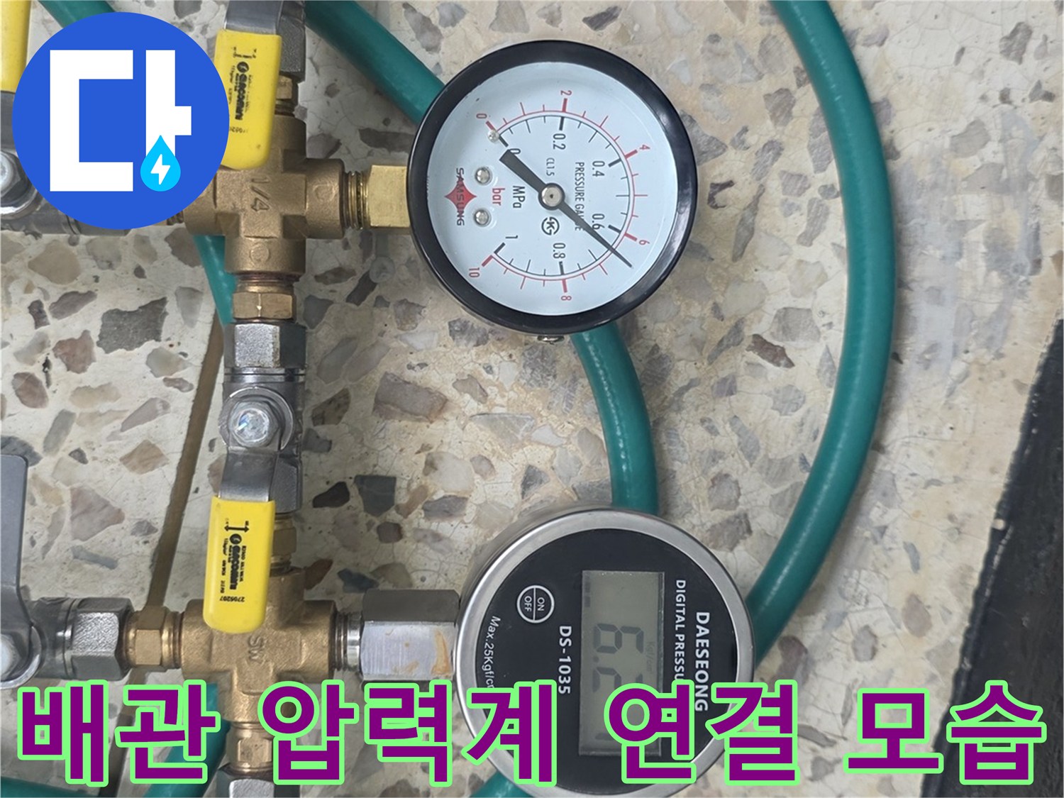 수도 계량기 부근에 설치된-압력 측정용 게이지와 호스 연결부