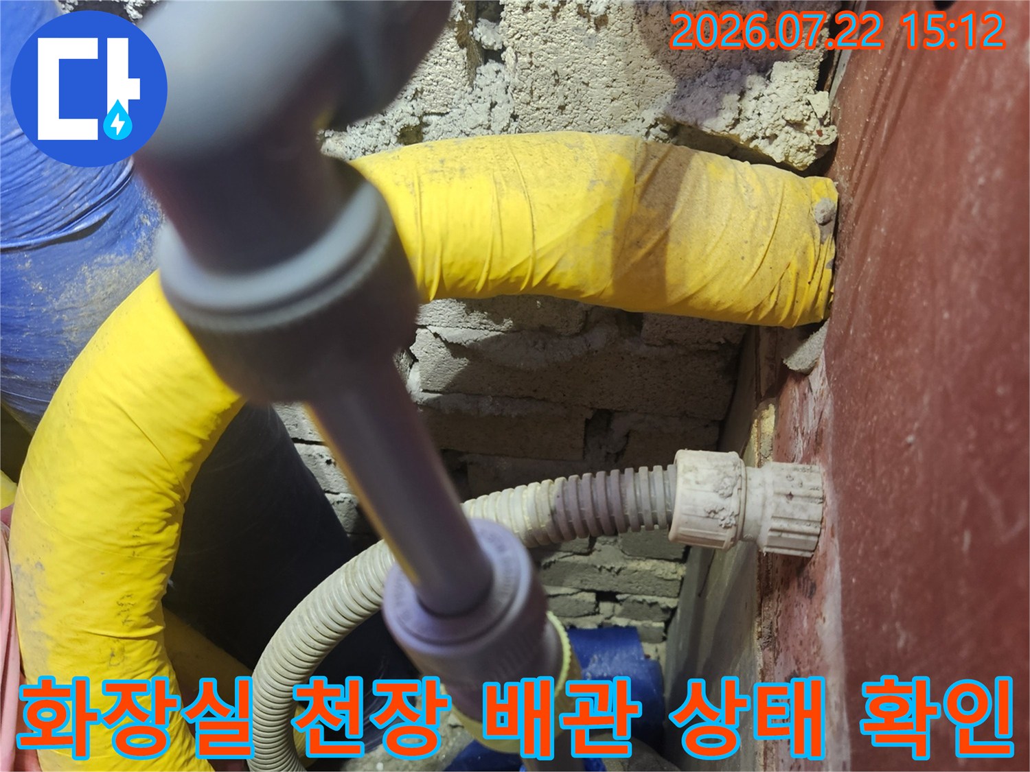노란색과 파란색 보온재로 감싸진 화장실 천장 내부의 복잡한 수도 배관 연결 부위-사진