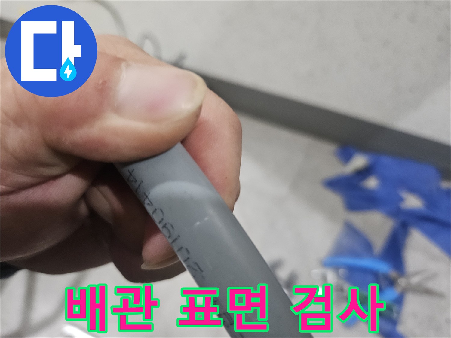 누수 부위를 찾기 위해 손으로 잡고 검사 중인 배관 부위