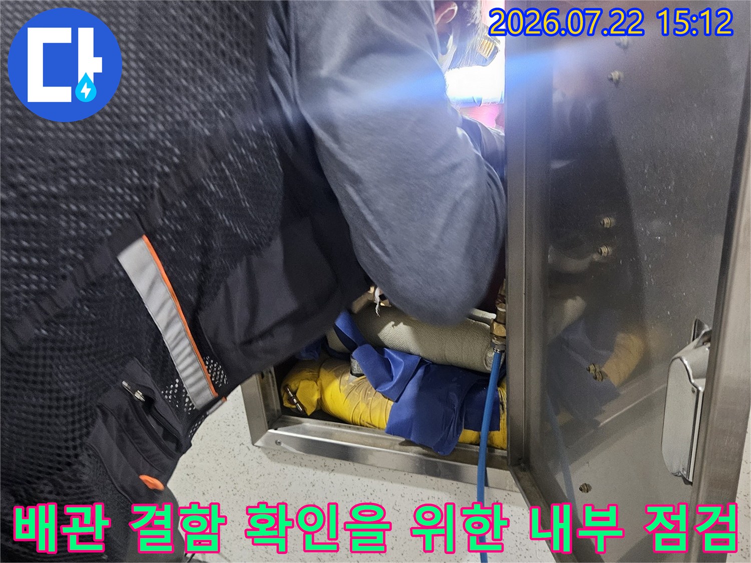 작업자가 상체를 숙여 천장 내부의 노란색 보온재 배관과 파란색 진단용 호스를 점검하는 현장 사진