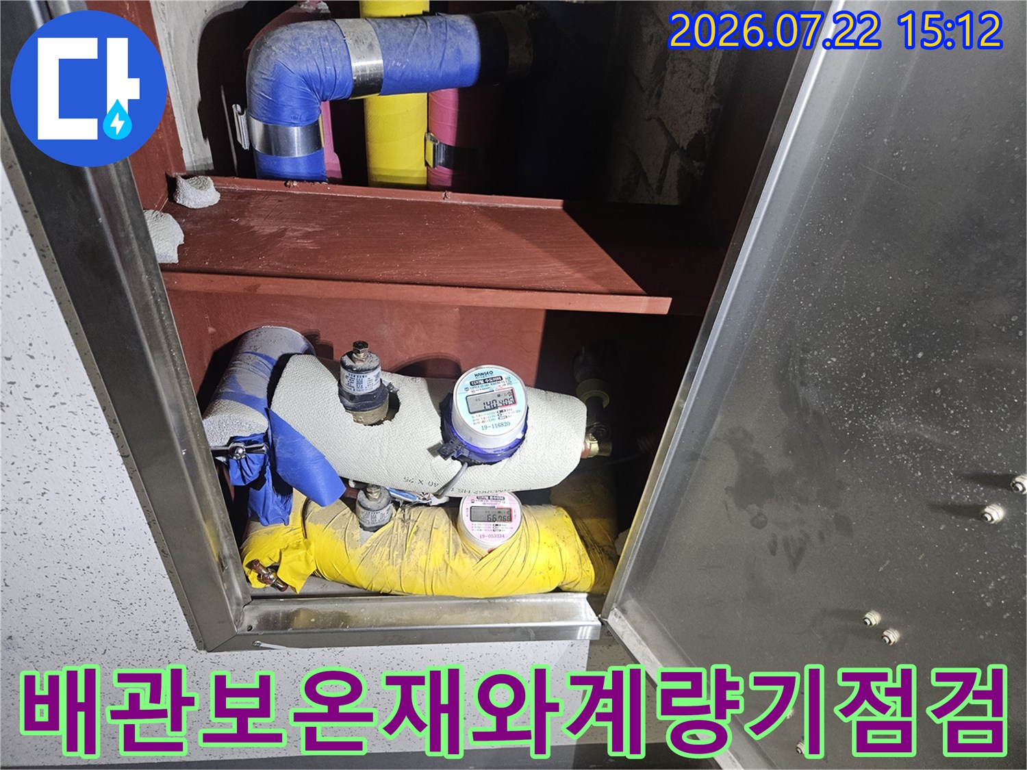 파란색과노란색 보온재로 감싸진 수도 배관-상단에 부착된 디지털 계량기 모습