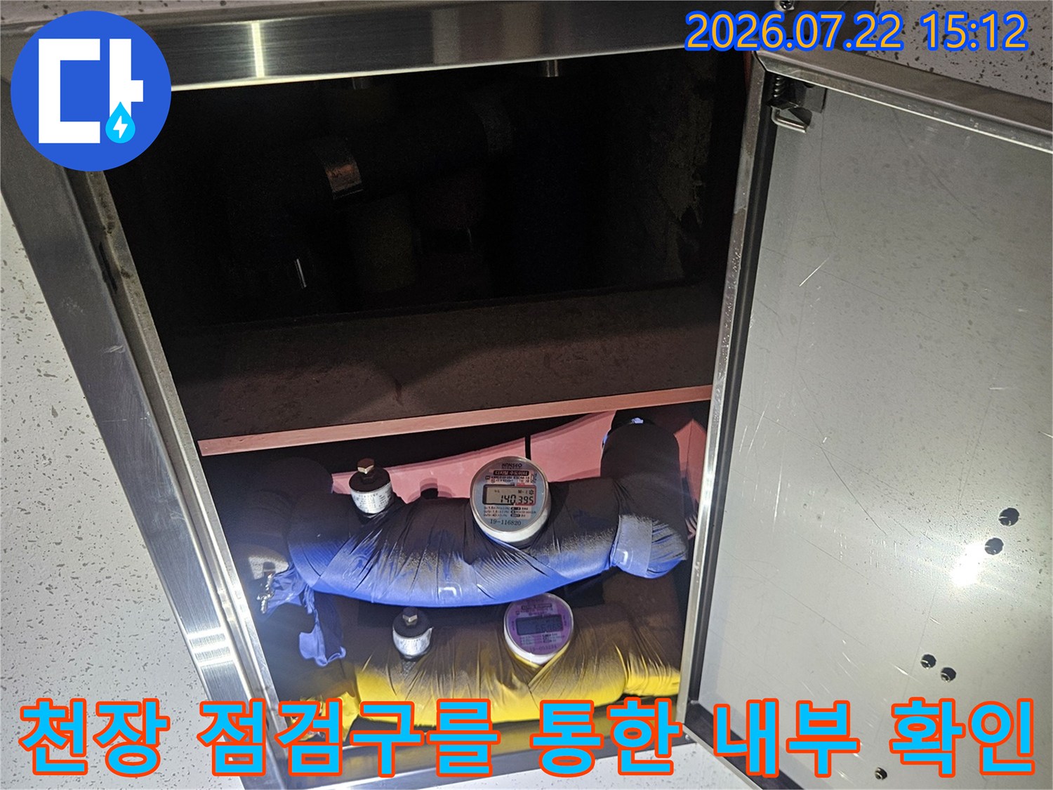 화장실-점검구가-열려있고-내부에-파란색과-노란색-배관-보온재가-보이는-모습