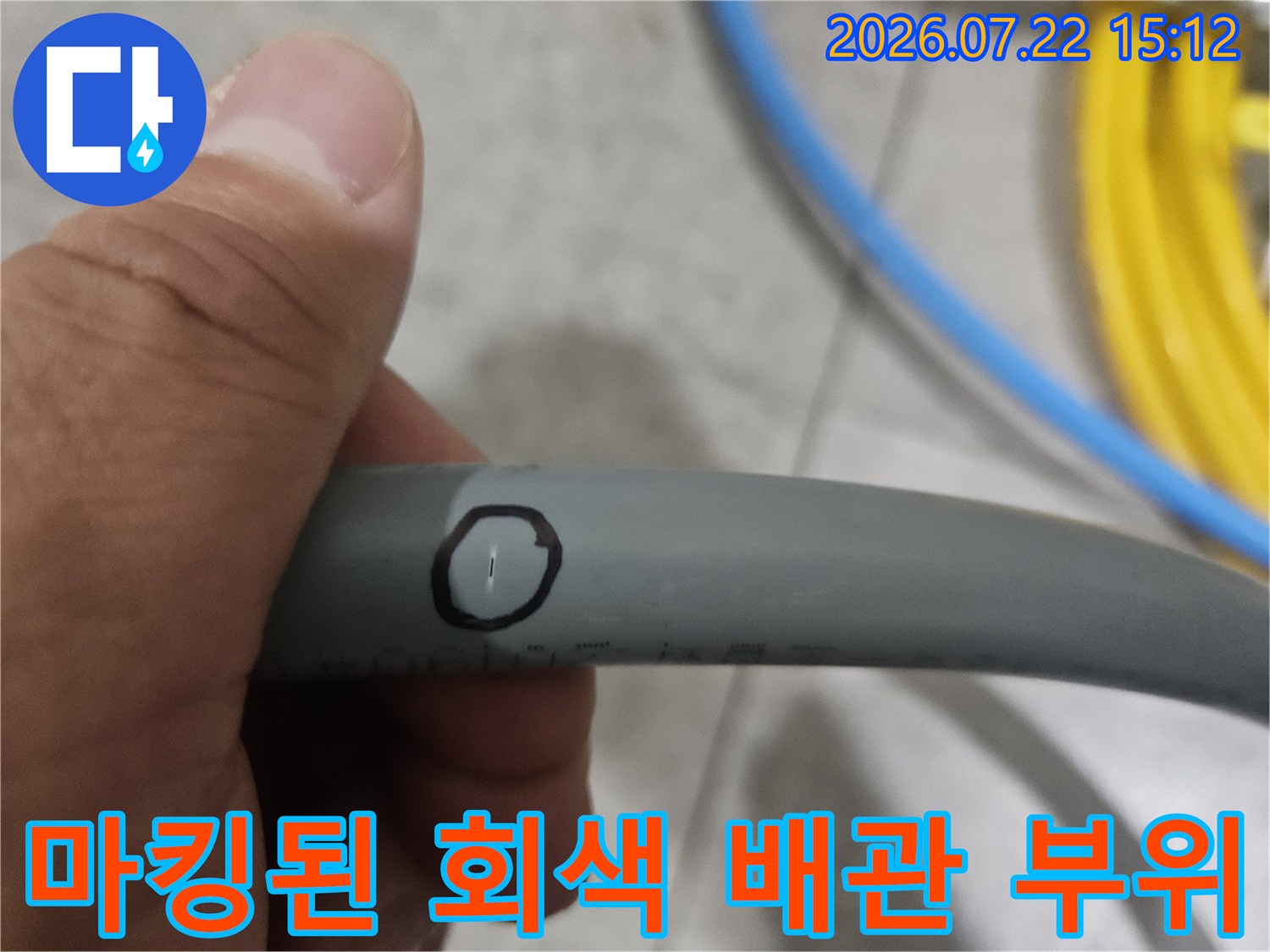 회색 플라스틱 배관의 누수 지점에 동그라미 표시가 그려진 사진