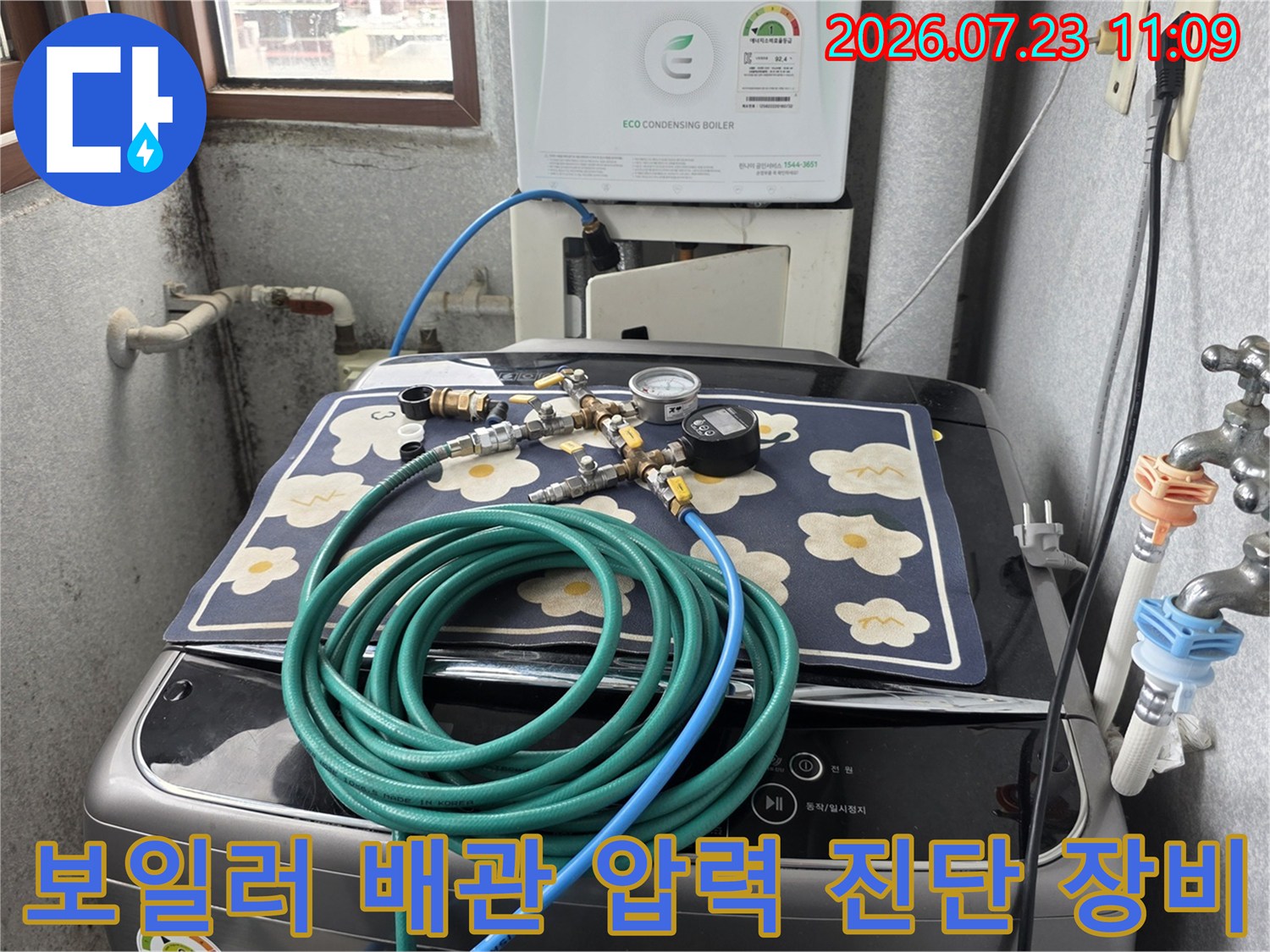 세탁기 위 매트 위에 배치된 누수 검사 전용 공압 게이지와 호스