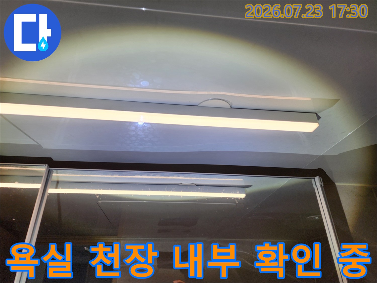 화장실 천장-조명과 마감재가 보이는 누수 점검 현장 사진