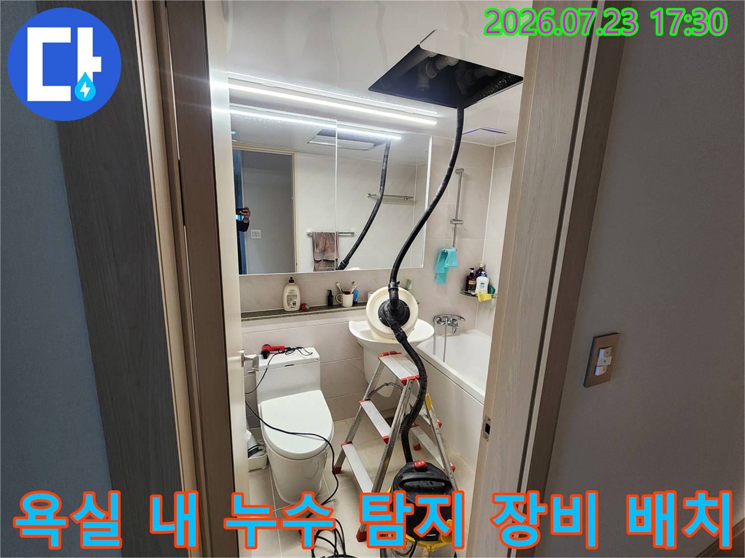 화장실 천장으로 연결된 검은색 내시경 호스와 작업용 사다리-노란색 집진기