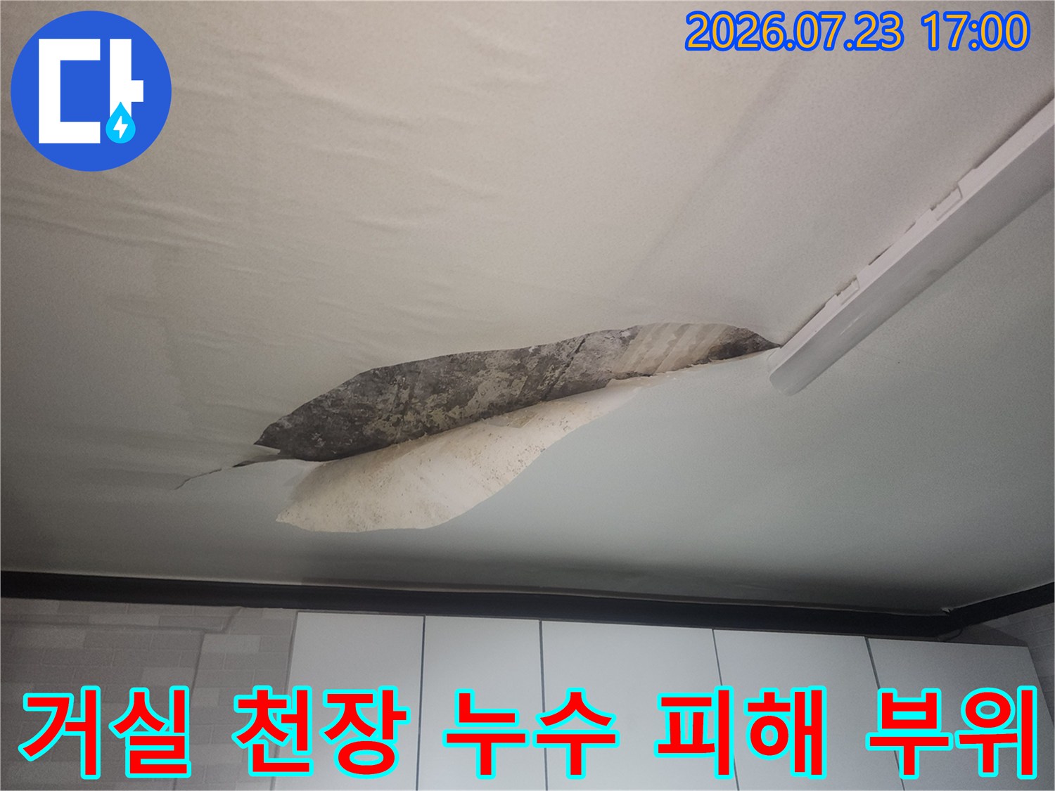 거실-천장의-실크벽지가-들뜨고-내부에-습기로-인한-어두운-얼룩이-보이는-모습
