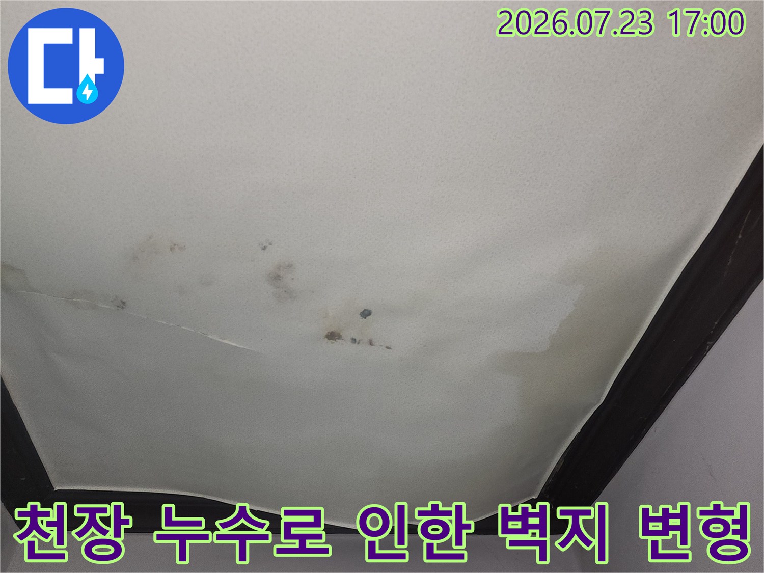 물샘으로 인해 천장 벽지가 울퉁불퉁하게 튀어나오고 갈색 오염이 진행된 모습-사진