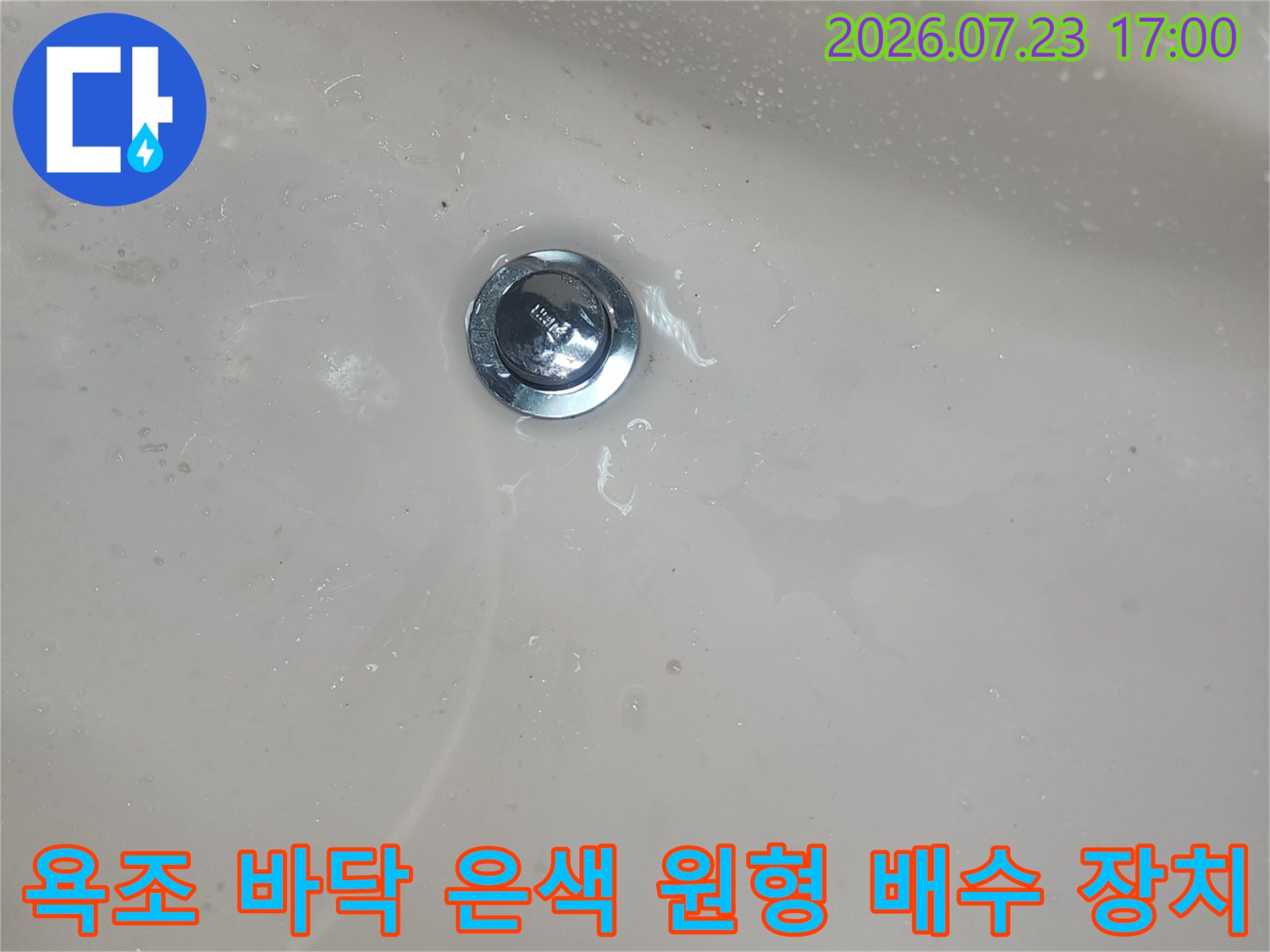 흰색 아크릴 욕조 내부에 설치된 금속 재질의 배수구-배출구 상세 사진