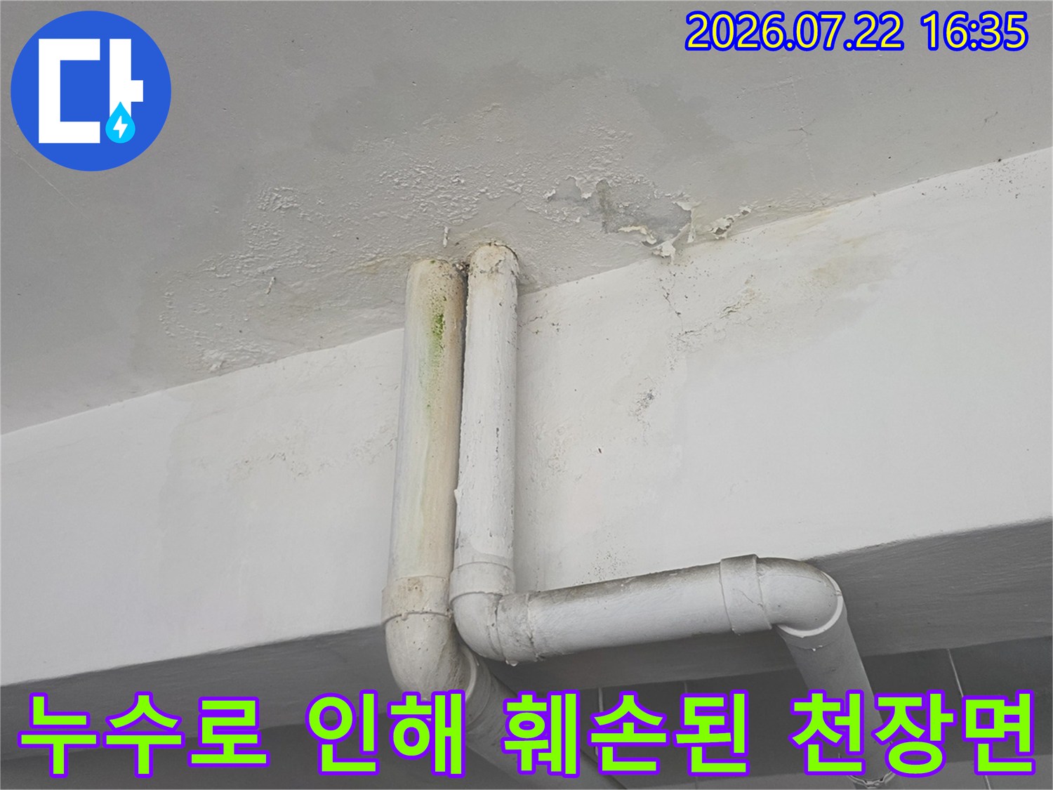 흰색 배관 상단부 천장에서 발견된 누수 얼룩과 페인트가 떨어진 모습