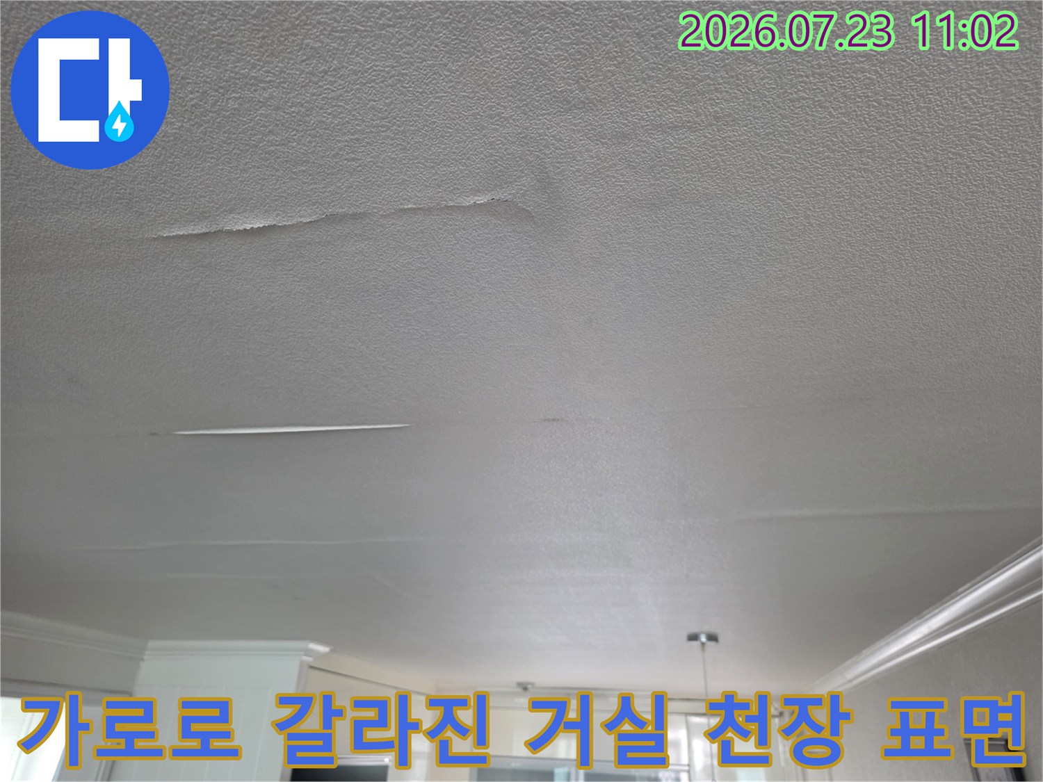 습기로 인해 변색되고 가로 방향으로 길게 찢어진 하얀색 거실 천장 마감재 사진