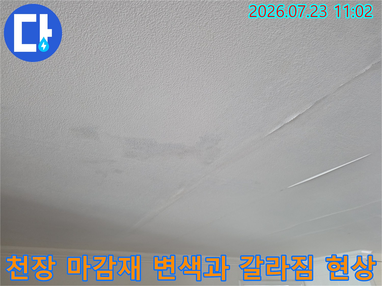 습기로 인해 얼룩진 거실 천장의 표면-길게 뻗은 균열 부위 강조