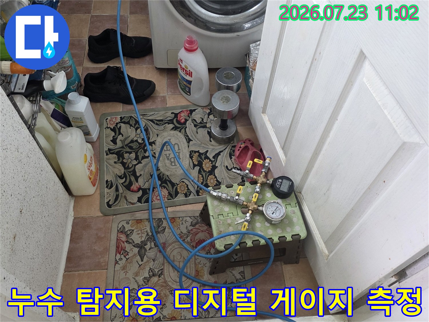 타일 바닥 위에 배치된 공압 테스트 장비와 배관에 연결된 파란색 라인들