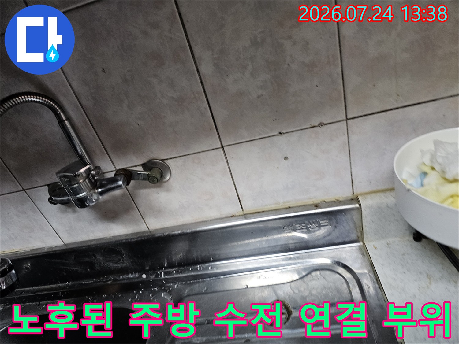 베이지색 타일 벽면에 설치된 구형 싱크대 수도꼭지-연결부 상세 사진