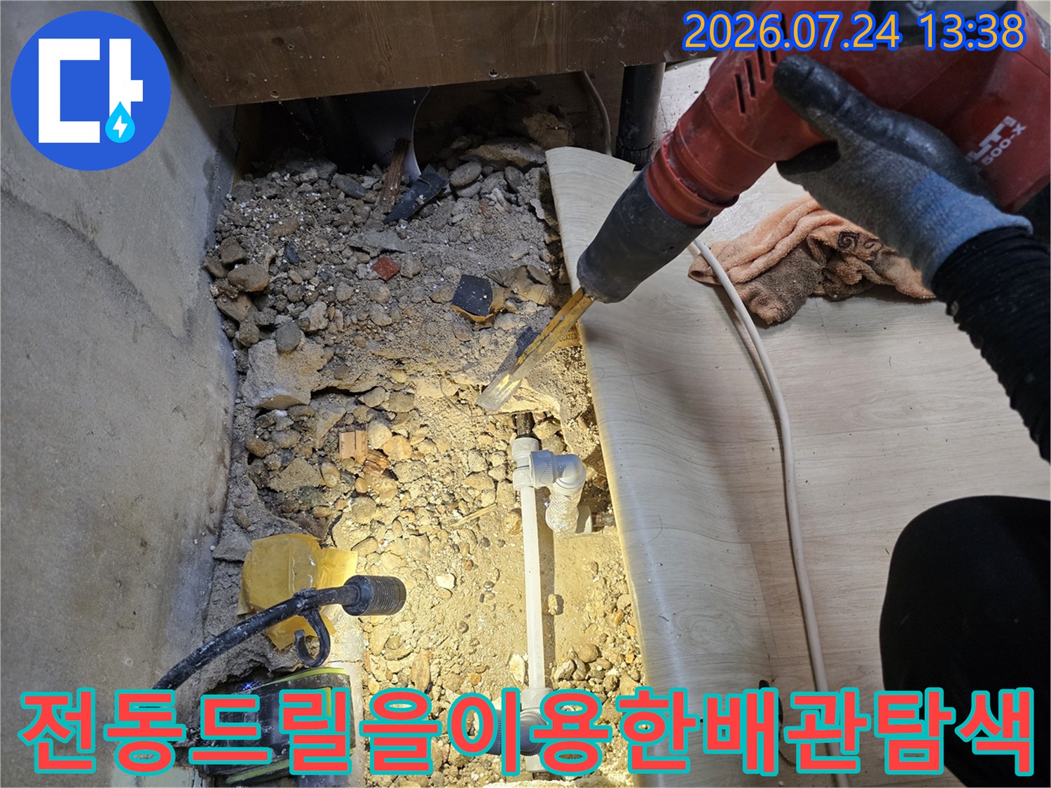 작업자가-장갑을-끼고-붉은색-함마드릴로-바닥의-콘크리트를-파내어-배관을-찾는-현장