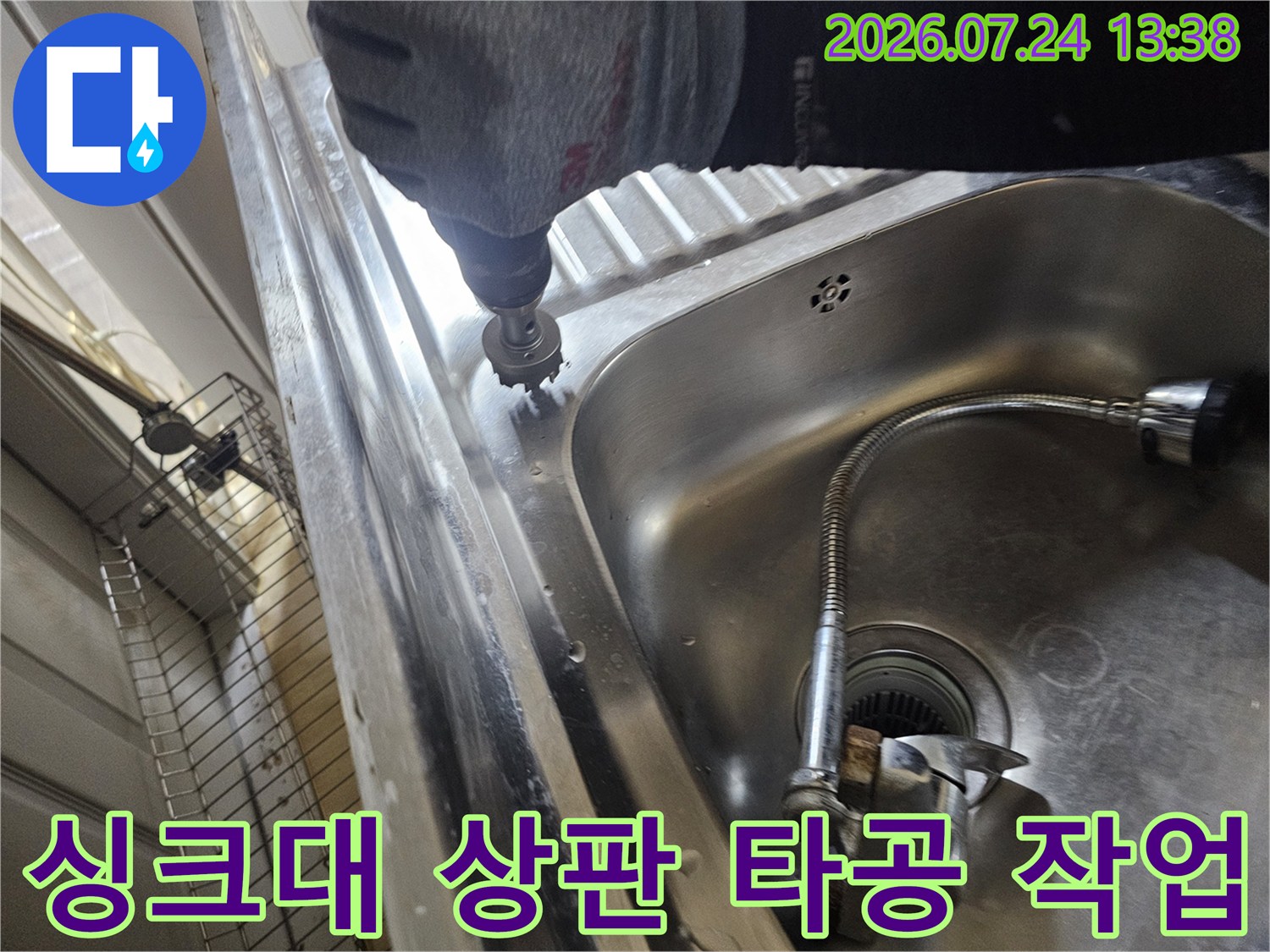 작업자가 전동 드릴을 사용하여 싱크대 상판 부근에 구멍을 뚫고 있는 모습