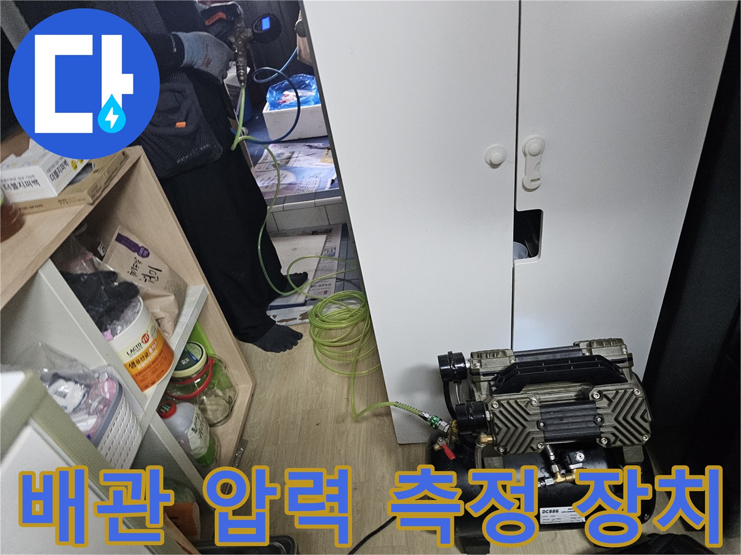 주방 싱크대 하부 공간에 배치된 누수 진단용 공압 테스트 기기