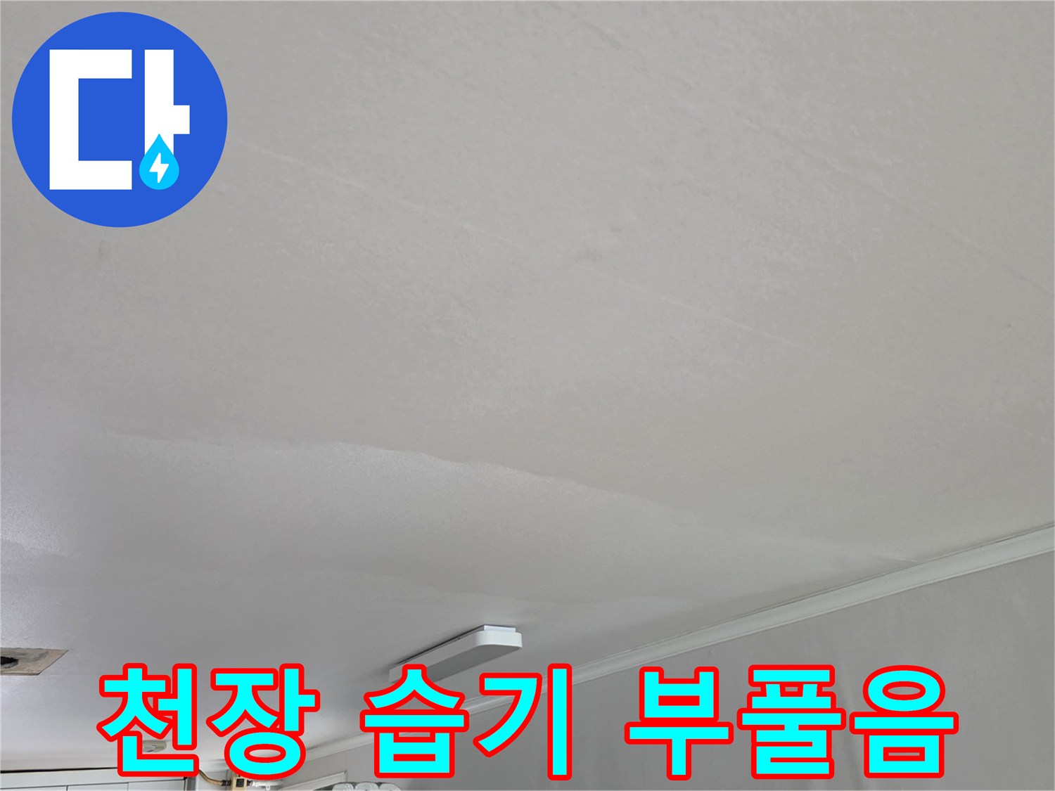 물샘 증상이 나타난 아파트 거실 천장의 도배 상태