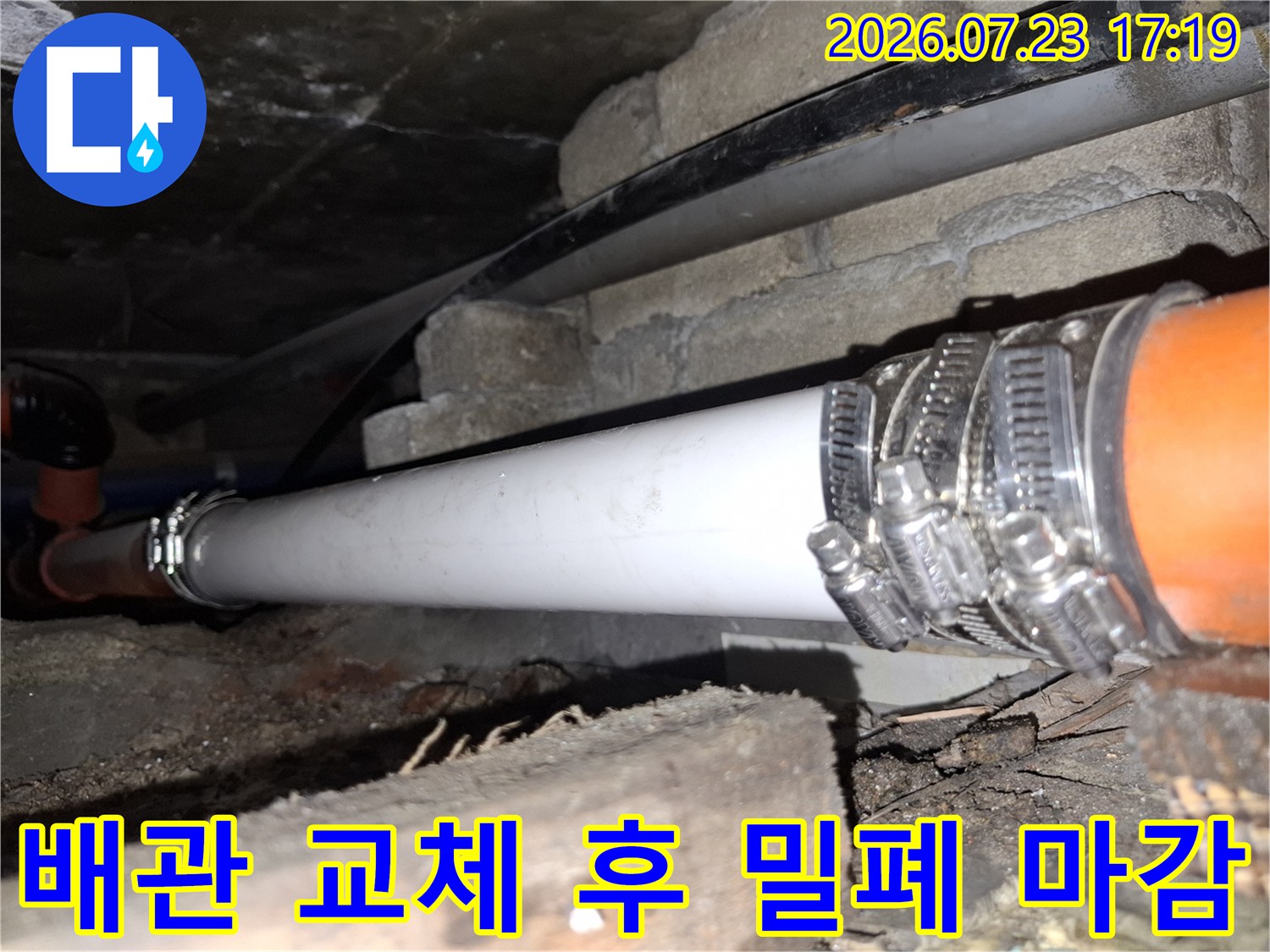 주황색 배관 끝단에 흰색 배관을 연결하고 밴드로 고정한 상세 사진
