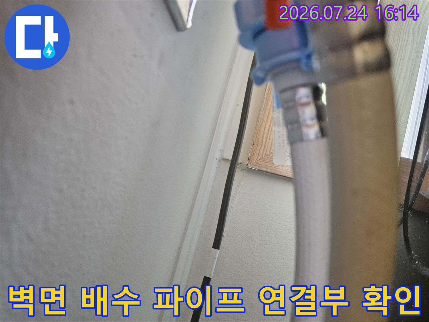 배수 호스가 벽면으로 들어가는 구간의 노출된 배관 부위 촬영