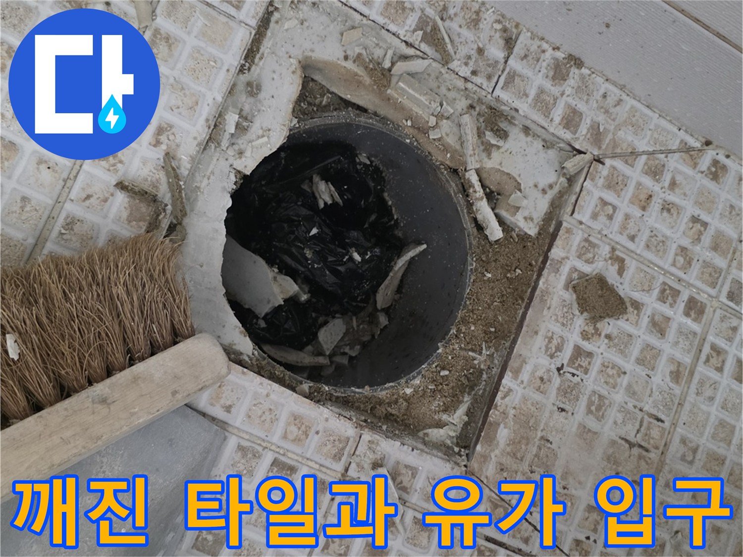 유가 주변의 깨진 타일 조각들과 노출된 배관 입구