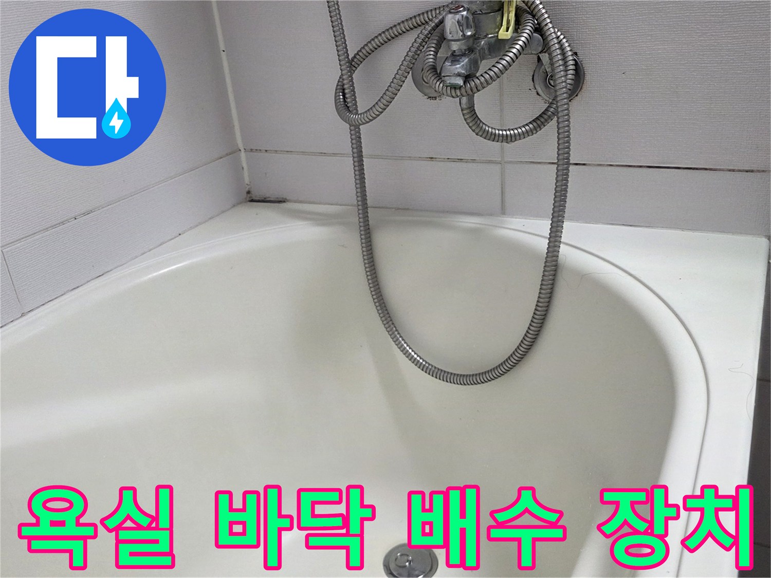 흰색 욕조 바닥의 배수구와 연결된 샤워기 호스 모습