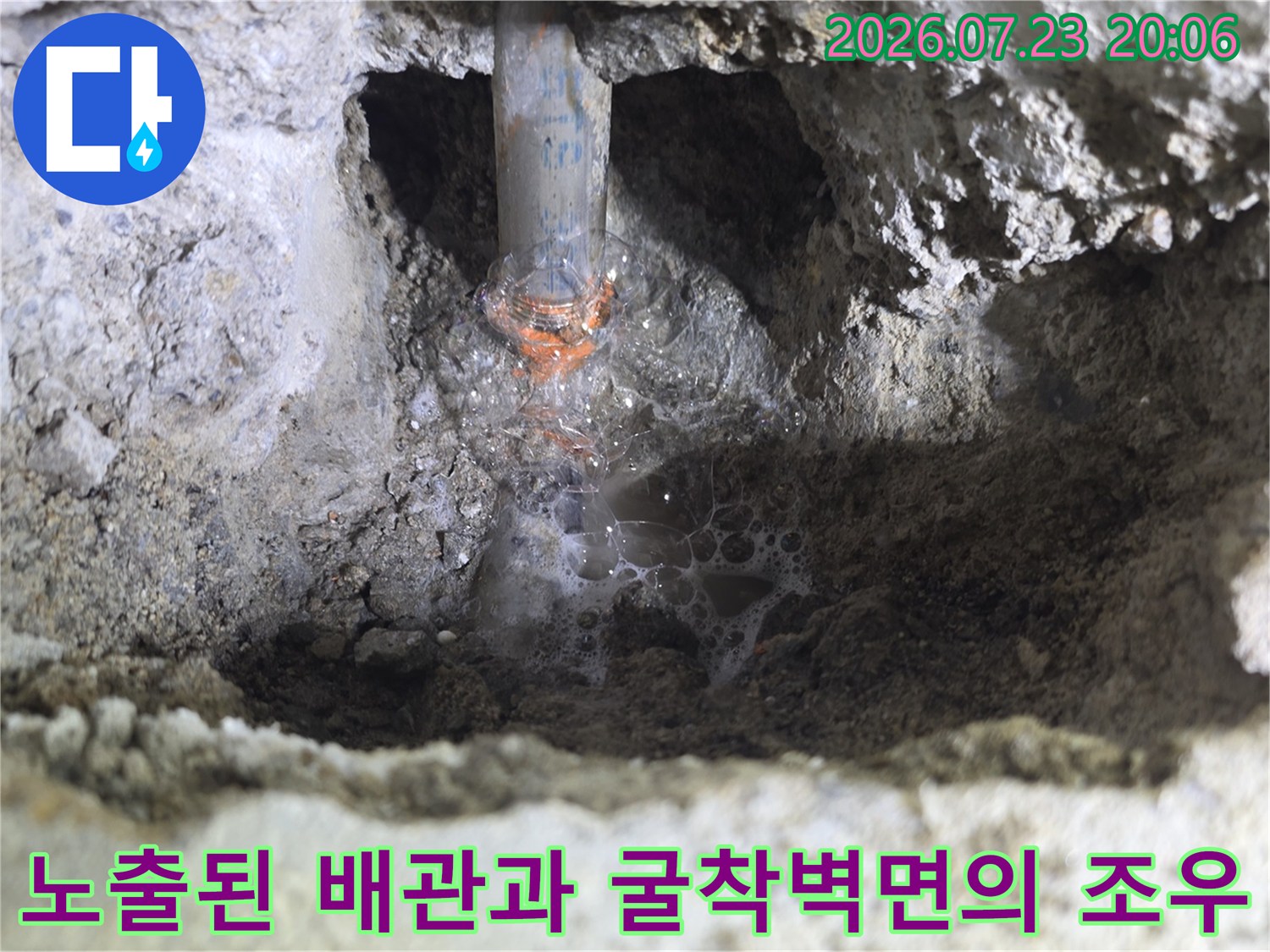거친 표면의 콘크리트와 연결된 회색 파이프 노출부