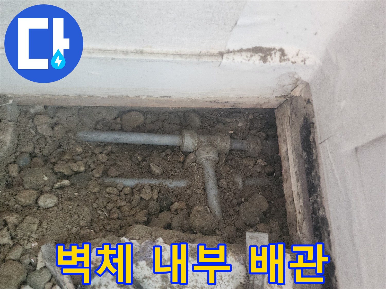 자갈과 흙으로 채워진 굴착 부위 내부에 보이는 배관 연결부