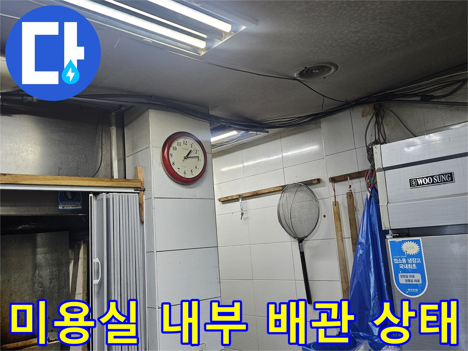 부천 미용실 내 벽면 타일과 상업용 냉장고 근처 배관 시설물 모습