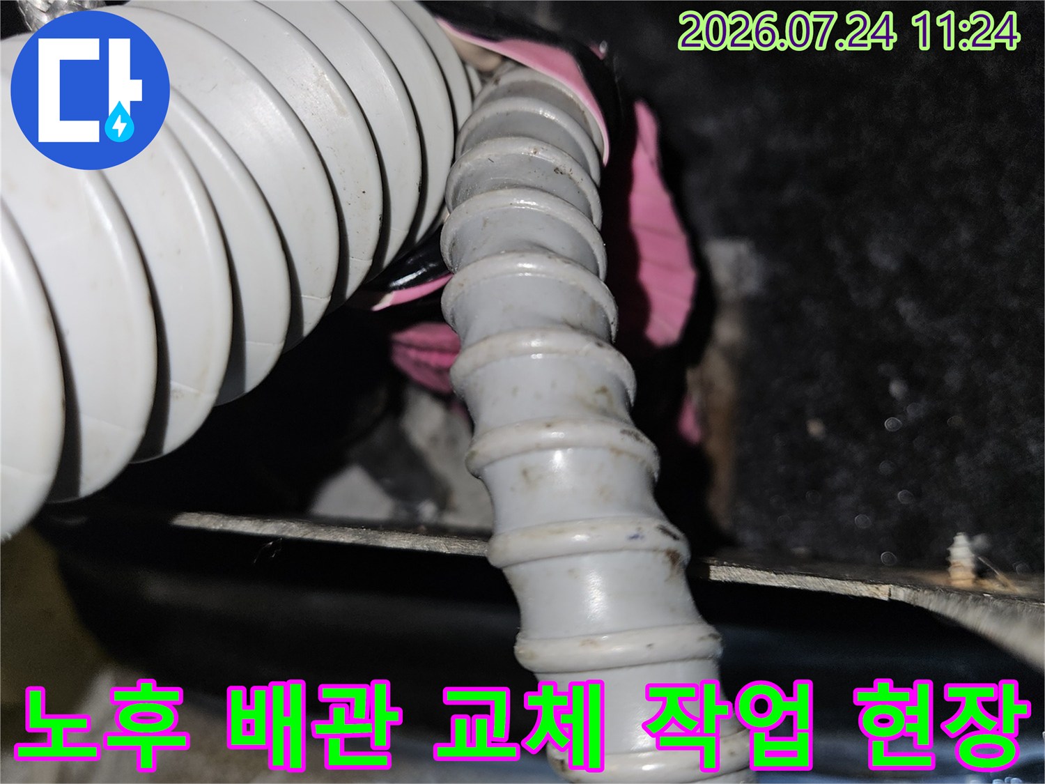파손된 온수용 주름관을 절단하고 새 관으로 연결하는 수선 공사 장면