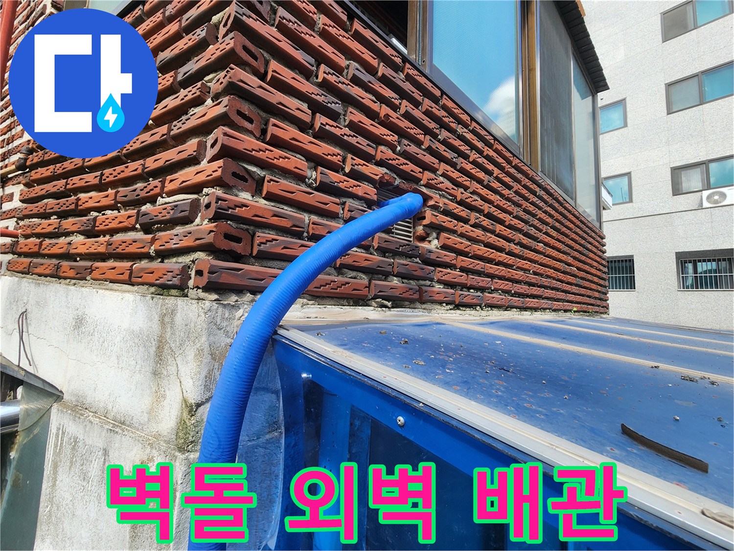 붉은 벽돌 구조물에 고정된 파란색 보온재 마감 배관
