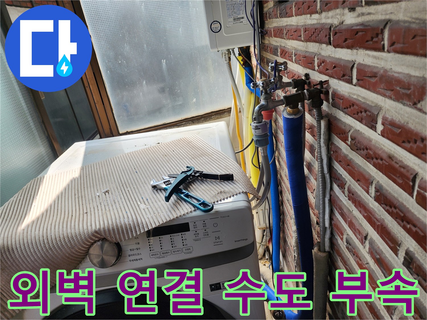 붉은 벽돌 외벽에 설치된 파란색 보온재 배관과 밸브 장치