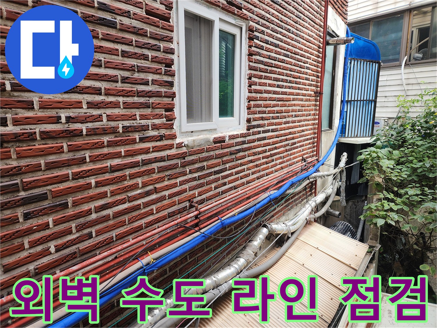 성북구 건물 외벽에 노출된 파란색 및 은색 배관들