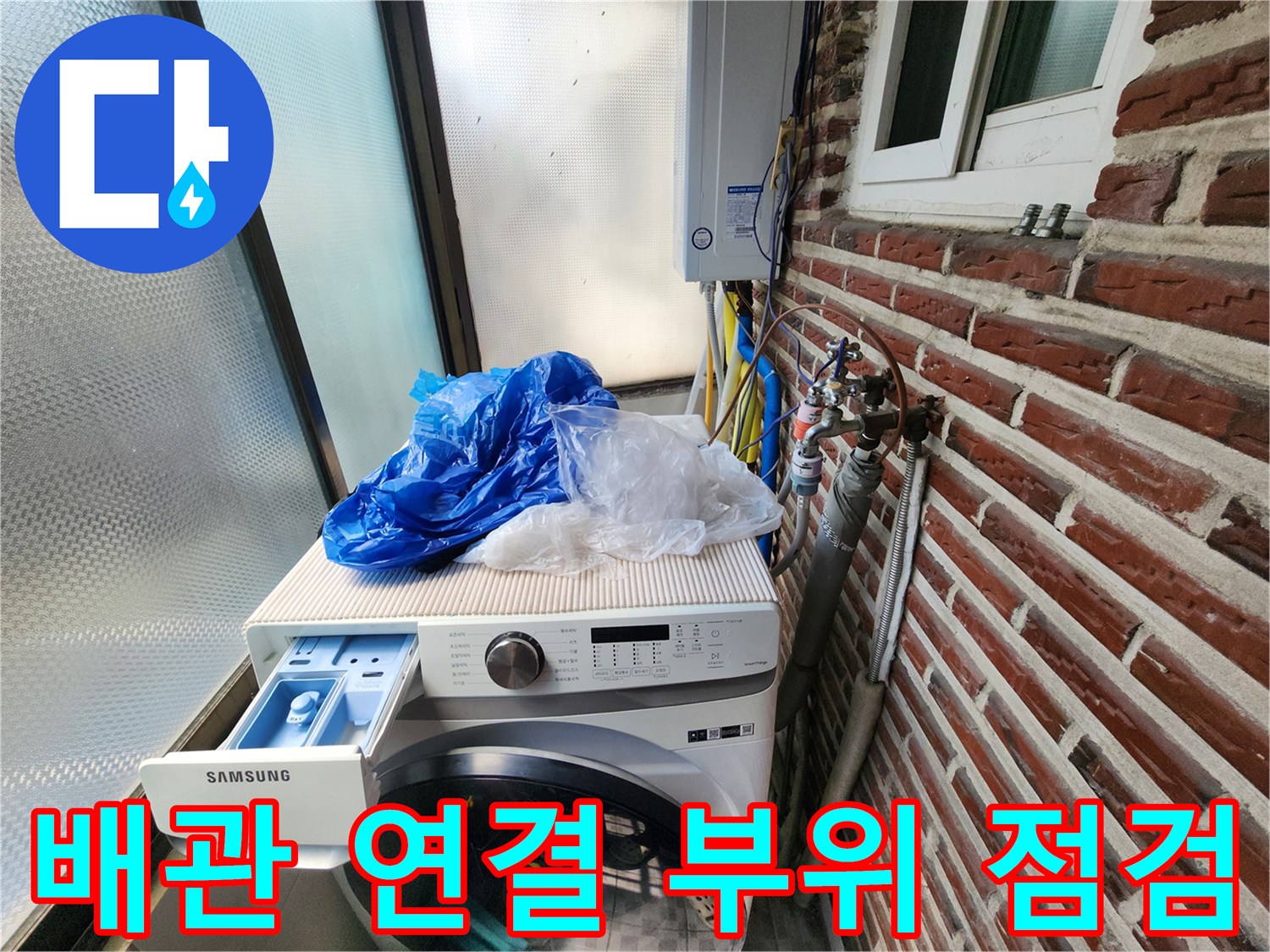 세탁기 옆 벽돌 외벽에 노출된 수도 계량기 및 배관 구조