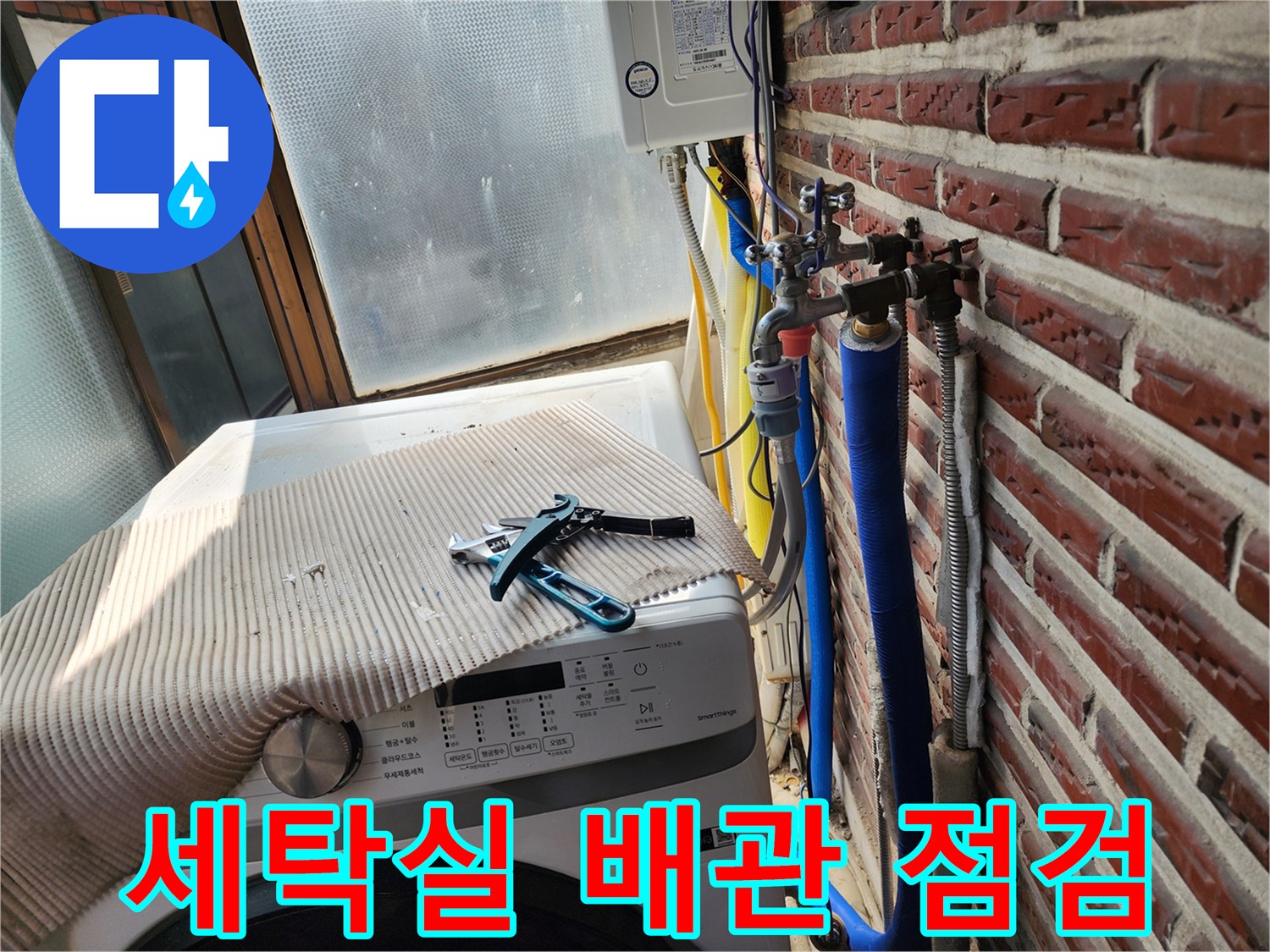 세탁기 옆에 놓인 공구와 외벽 노출 배관 상태