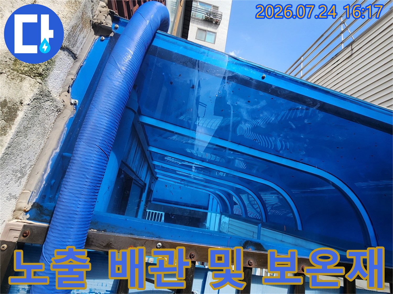 파란색 외장용 보온재로 마감된 노출 수도 배관의 상세 모습