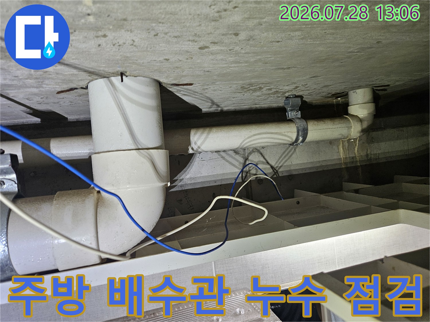 하수 배수관 연결 부위의 노출된 배관과 주변 슬래브 상태