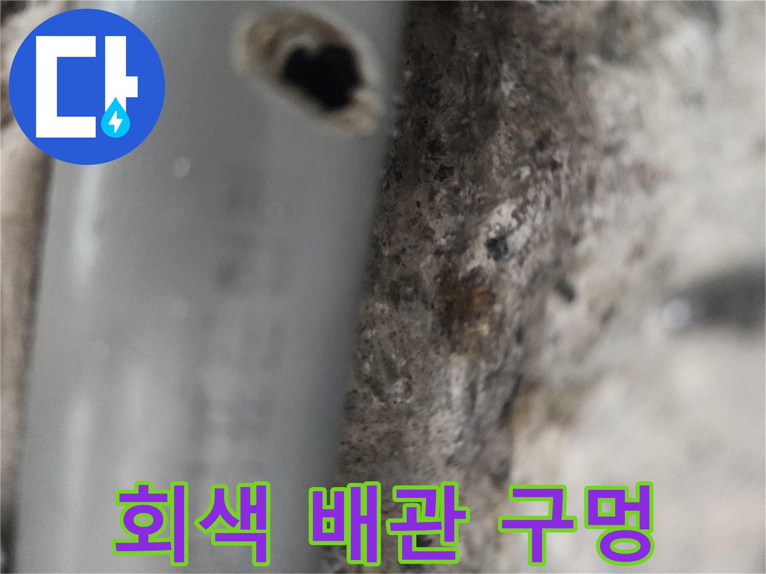 파손된 회색 배관과 주변 흙먼지 섞인 콘크리트