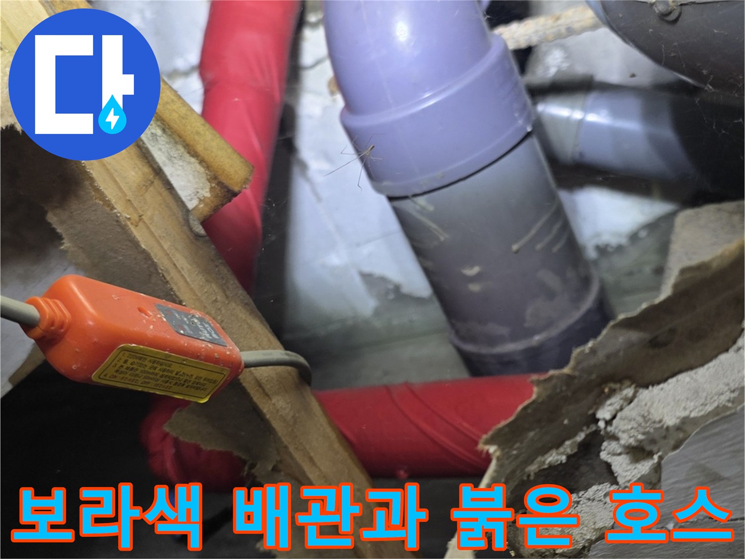 천장 내부의 보라색 에이콘 배관과 붉은색 보온재가 씌워진 급수관 모습입니다.