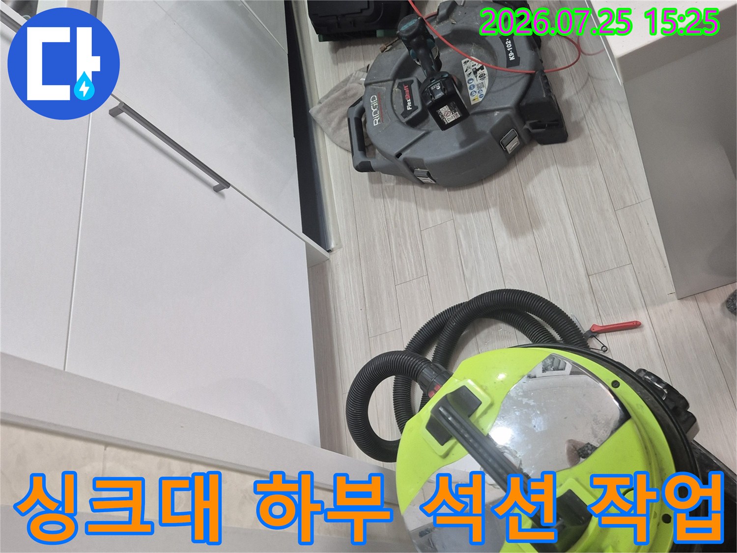 싱크대 밑 공간에서 강력한 석션기와 배관 장비를 사용하여 누수 원인을 파악하는 모습