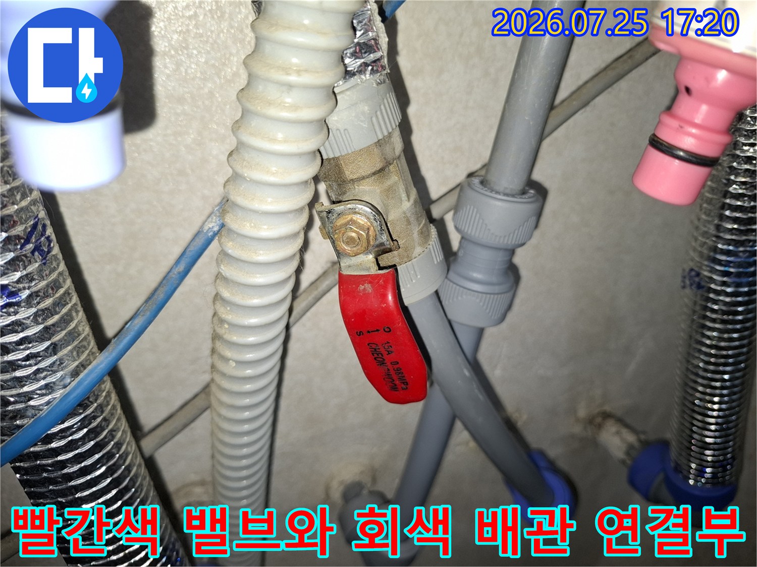 회색 배관과 적색 핸들 밸브가 연결되어 있는 누수 수리 현장 사진